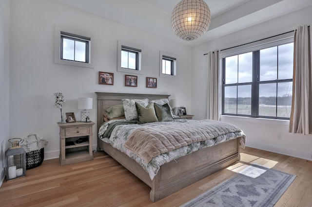 bedroom with light wood finished floors and baseboards