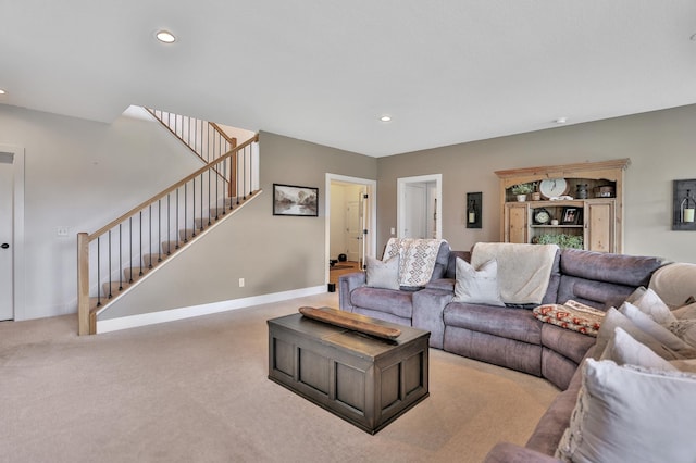 carpeted living area with stairs, baseboards, and recessed lighting