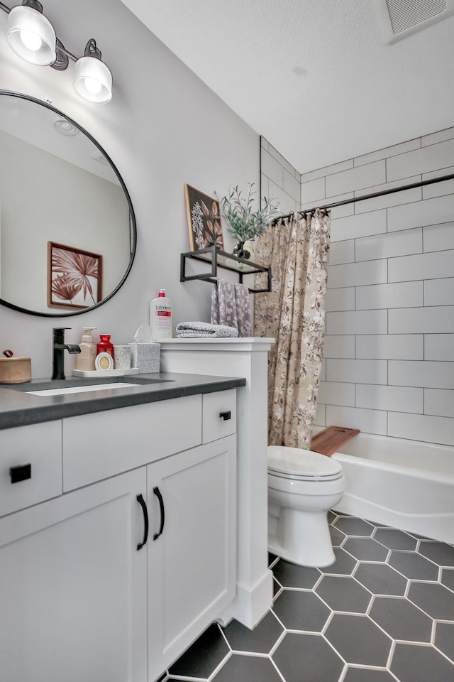 bathroom featuring visible vents, toilet, vanity, a textured ceiling, and tile patterned flooring