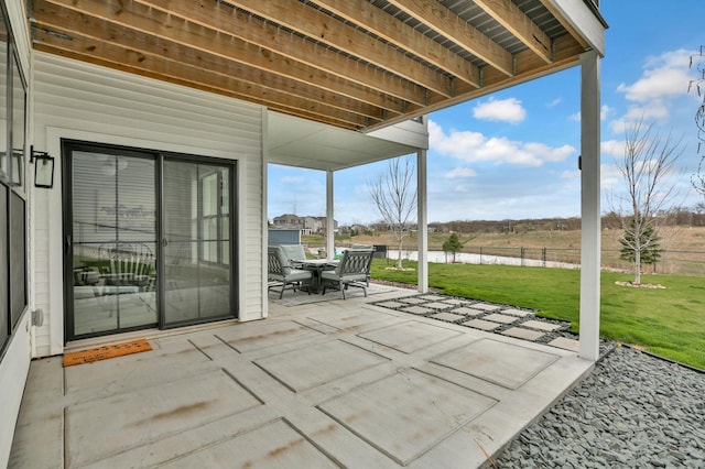 view of patio / terrace featuring outdoor dining space, a water view, and fence