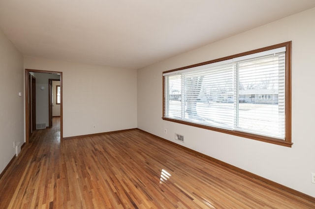 spare room with baseboards, visible vents, and light wood-style floors