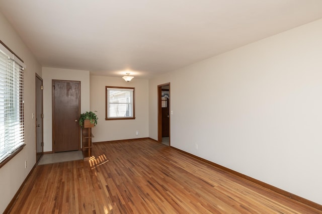 unfurnished room with wood finished floors and baseboards