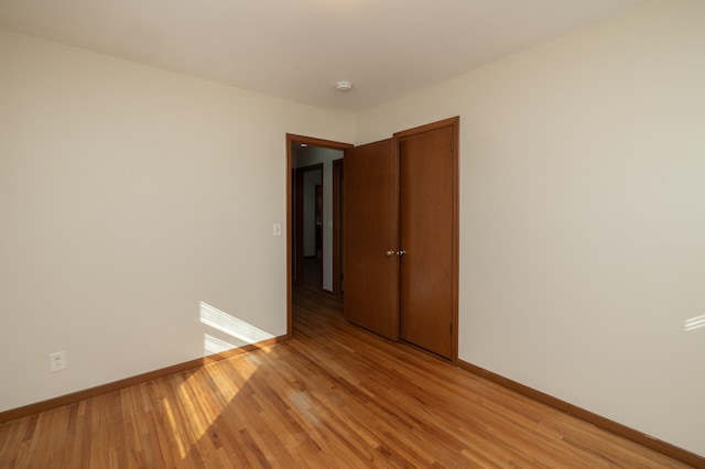 unfurnished room featuring light wood-style flooring and baseboards