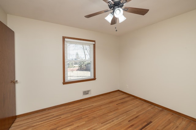 empty room featuring light wood-type flooring, baseboards, and visible vents