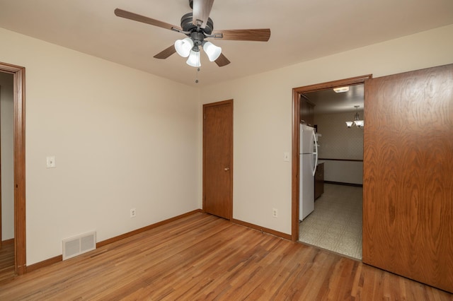 unfurnished bedroom featuring visible vents, baseboards, a closet, light wood-type flooring, and freestanding refrigerator