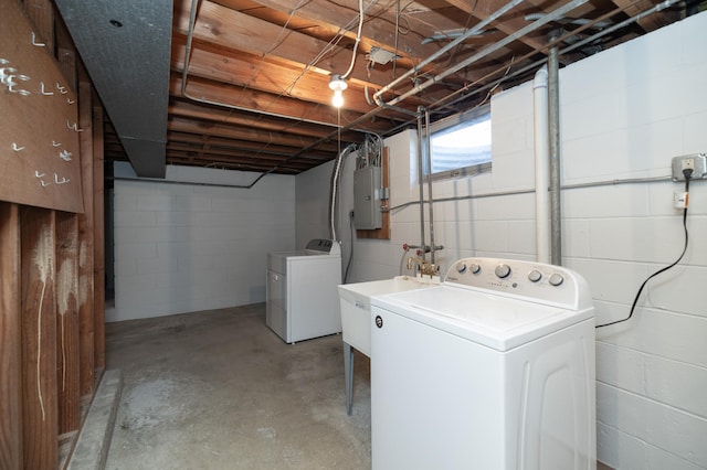 washroom with washing machine and dryer, laundry area, electric panel, and a sink