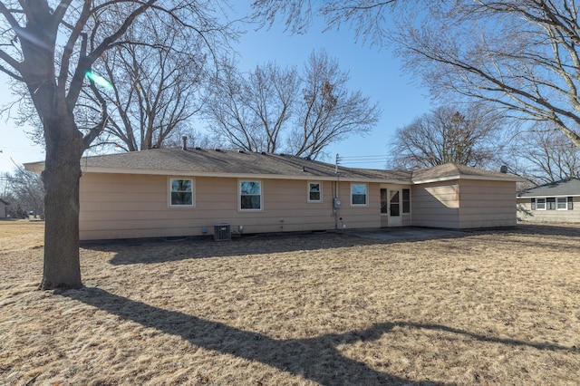 back of house featuring central air condition unit and a yard