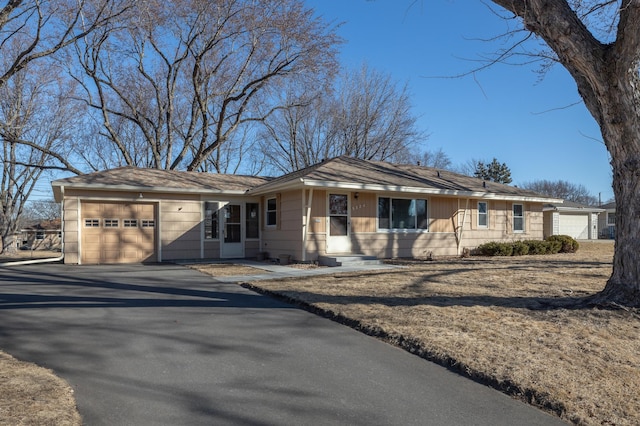 ranch-style home featuring a garage and driveway