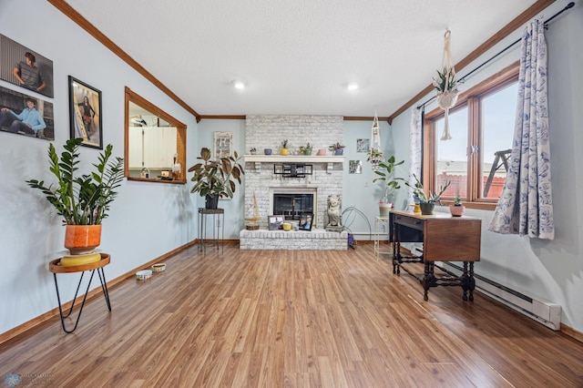 living area featuring ornamental molding, a fireplace, baseboards, and wood finished floors