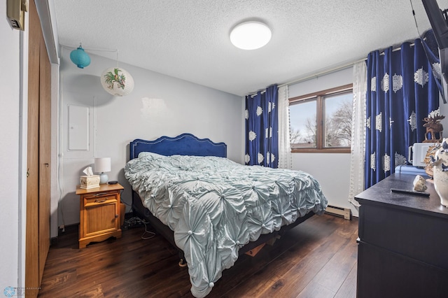 bedroom with a baseboard radiator, dark wood finished floors, and a textured ceiling