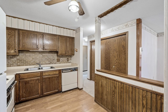 kitchen with a sink, light countertops, light wood-type flooring, stainless steel electric range, and dishwasher