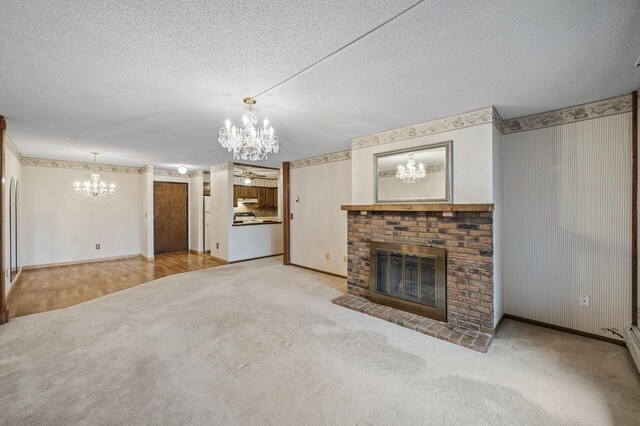 unfurnished living room featuring a textured ceiling, carpet, a fireplace, and an inviting chandelier