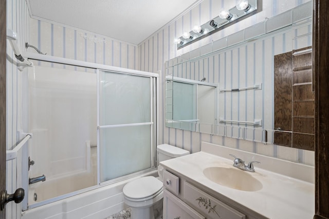 bathroom with shower / bath combination with glass door, toilet, a textured ceiling, vanity, and wallpapered walls