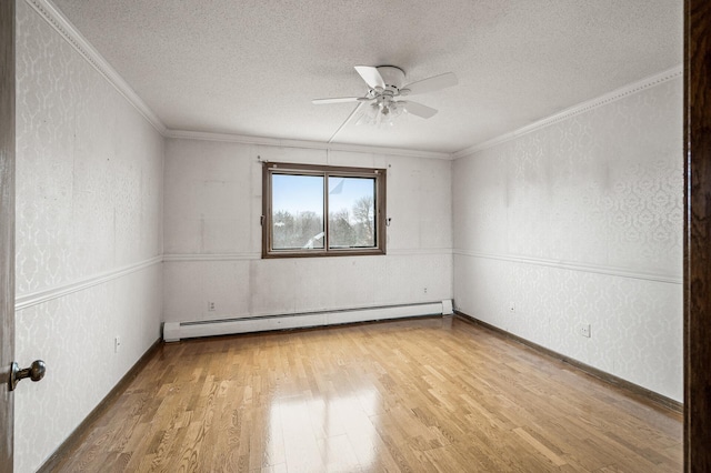 spare room with light wood-style floors, baseboard heating, a textured ceiling, and a textured wall