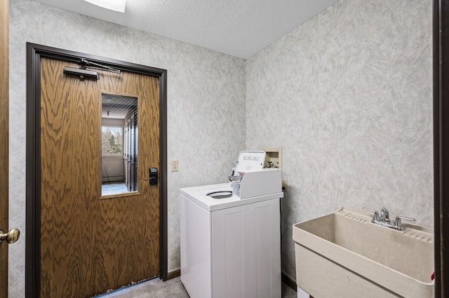 laundry room featuring washer / dryer, laundry area, a sink, and a textured ceiling