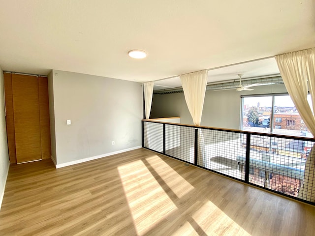 spare room with ceiling fan, baseboards, and wood finished floors