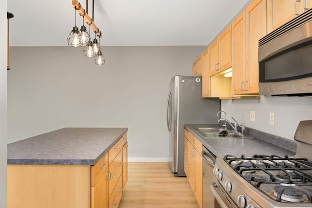 kitchen featuring stainless steel appliances, light brown cabinetry, a sink, dark countertops, and light wood-style floors
