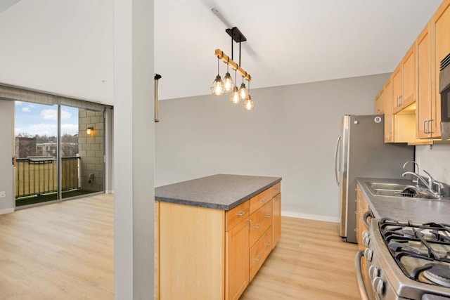 kitchen with light brown cabinetry, a sink, dark countertops, baseboards, and light wood-style floors