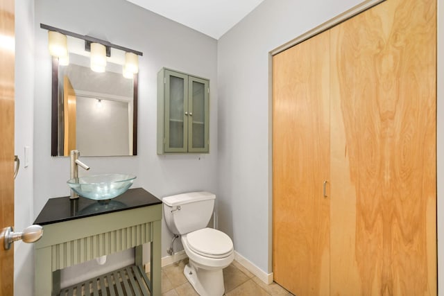 bathroom with tile patterned floors, baseboards, vanity, and toilet