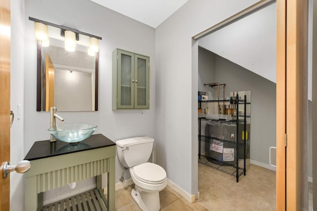 half bath with vanity, toilet, and baseboards
