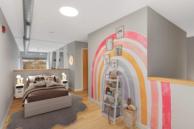bedroom with baseboards and wood finished floors