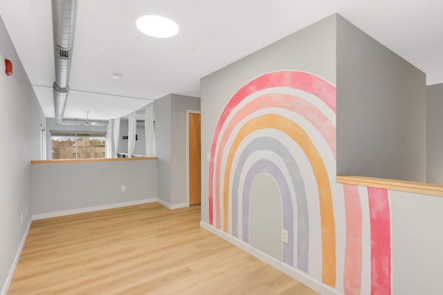 hall featuring baseboards and wood finished floors