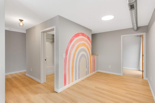 spare room featuring baseboards and light wood-type flooring