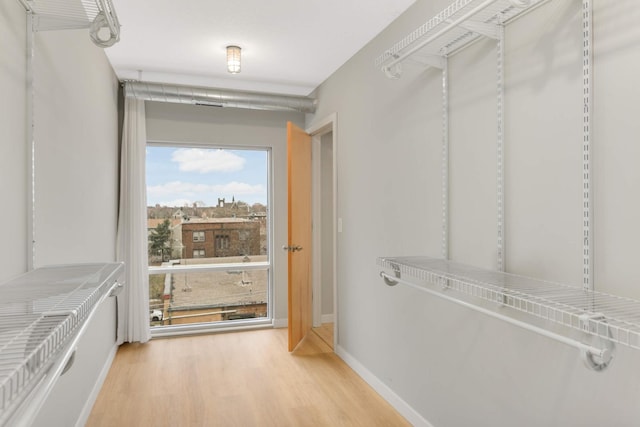 walk in closet featuring light wood finished floors