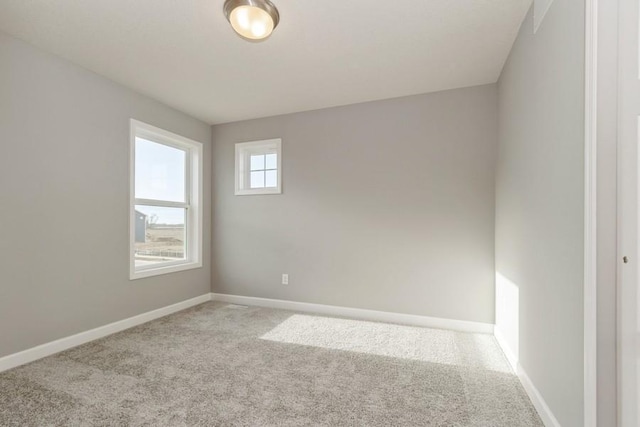 empty room featuring carpet and baseboards