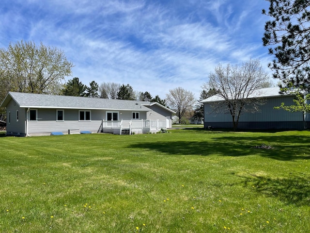 back of house with a deck and a yard