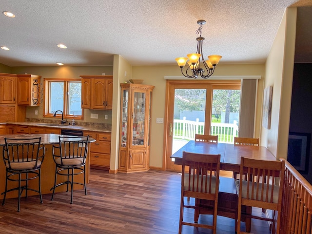 kitchen featuring a wealth of natural light, dark wood-style flooring, a notable chandelier, and a sink