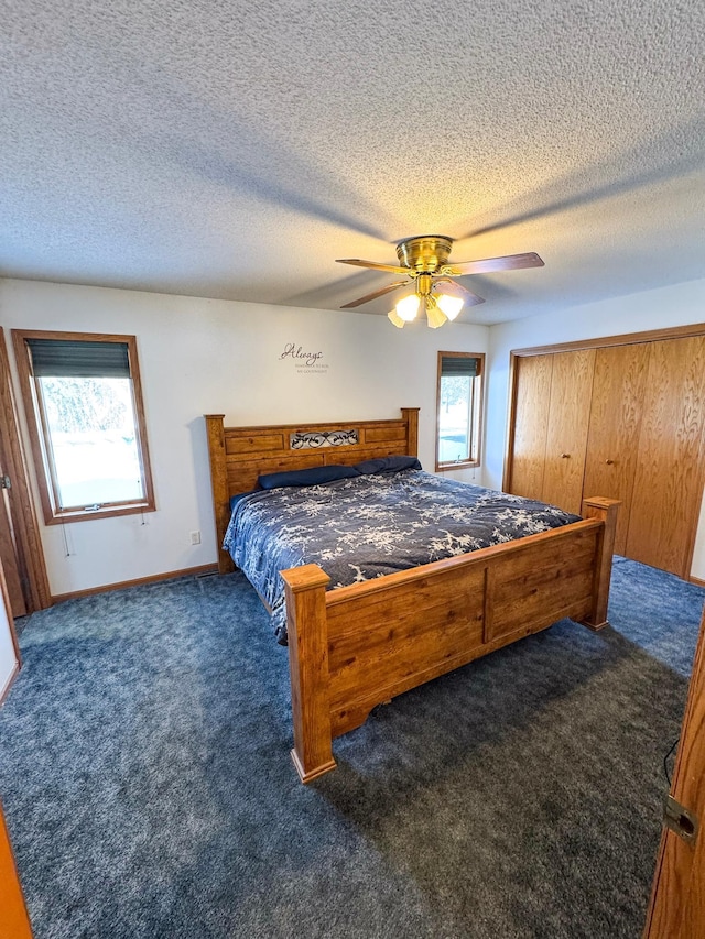 carpeted bedroom featuring a closet, ceiling fan, a textured ceiling, and baseboards