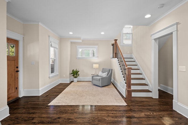 foyer with ornamental molding, stairs, and wood finished floors