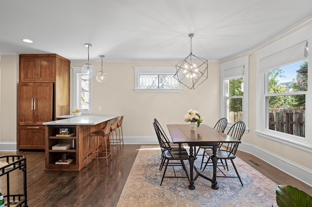 dining area featuring a chandelier, recessed lighting, dark wood-type flooring, baseboards, and crown molding