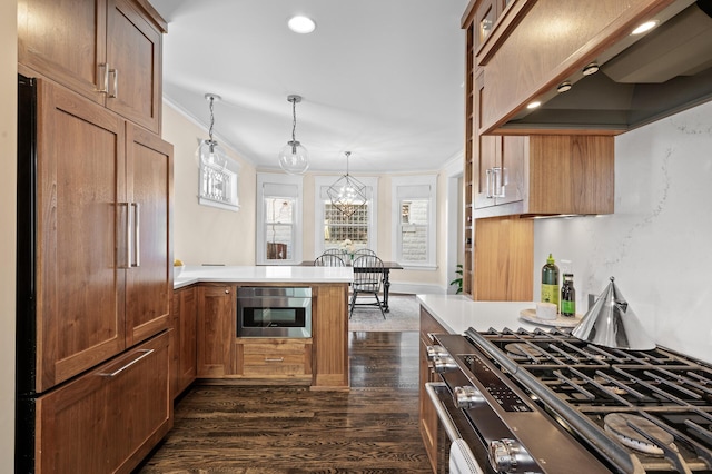 kitchen with a peninsula, premium range hood, paneled built in fridge, light countertops, and gas stove