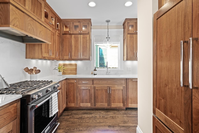 kitchen featuring dark wood-style flooring, brown cabinets, glass insert cabinets, a sink, and high end range