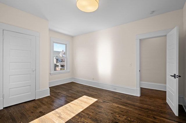 empty room featuring baseboards and wood finished floors