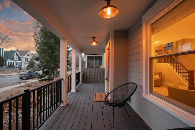 deck with covered porch and a residential view