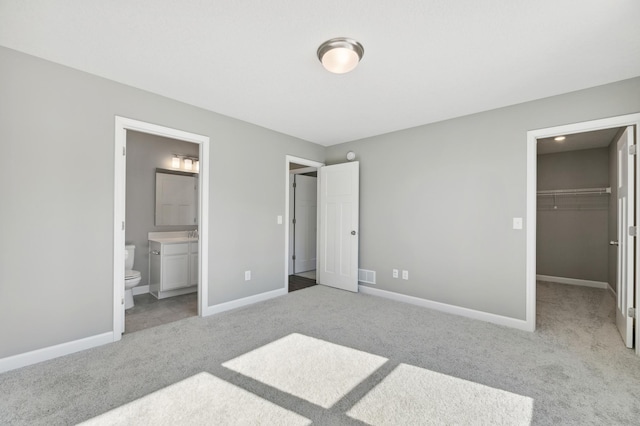 bedroom with carpet floors, visible vents, baseboards, a spacious closet, and a closet