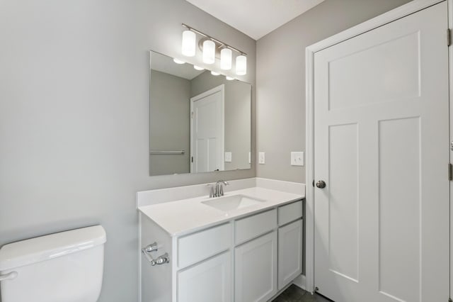 half bathroom with vanity and toilet