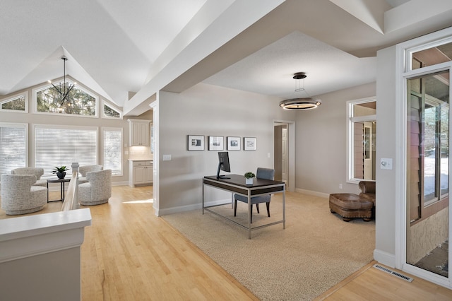 foyer with baseboards, visible vents, lofted ceiling, light wood-type flooring, and a notable chandelier