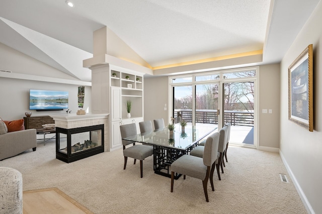 dining space featuring light carpet, baseboards, visible vents, and a tile fireplace