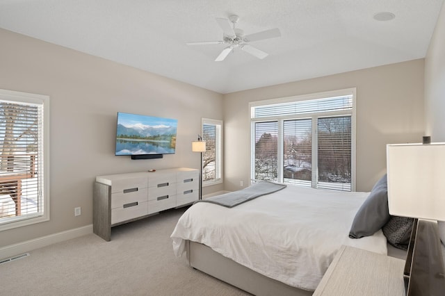 bedroom featuring baseboards, visible vents, a ceiling fan, and light colored carpet