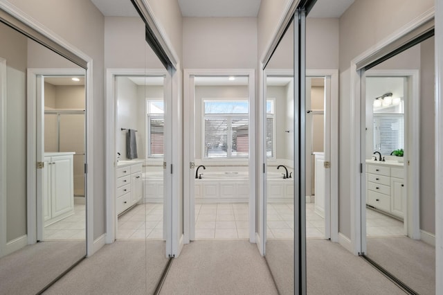 hallway featuring light carpet and light tile patterned floors