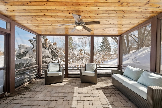 unfurnished sunroom with wooden ceiling and a ceiling fan