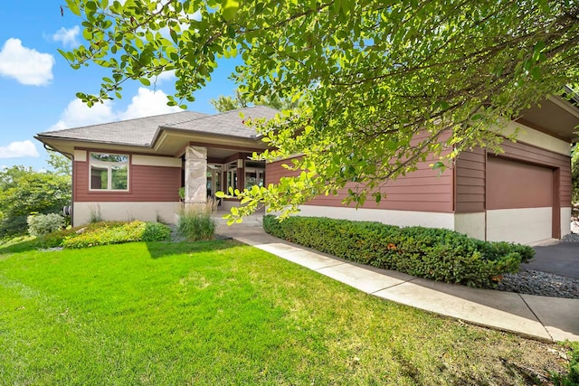 view of front of home with an attached garage and a front lawn