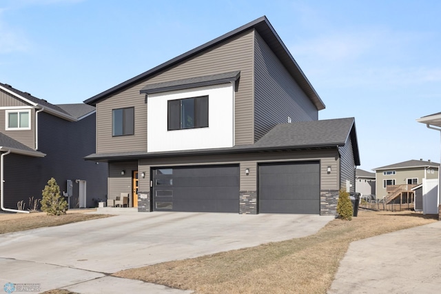 contemporary house featuring stone siding, concrete driveway, and an attached garage