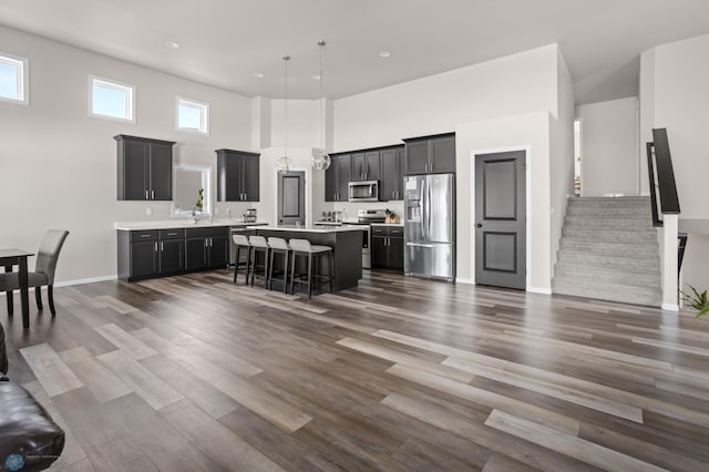 752 Cathy Dr W, West Fargo, ND 58078 - kitchen featuring a center island, light countertops, a kitchen breakfast bar, stainless steel appliances, and dark wood-style flooring