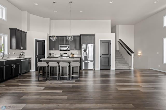 752 Cathy Dr W, West Fargo, ND 58078 - kitchen with a kitchen island with sink, a high ceiling, appliances with stainless steel finishes, a breakfast bar area, and light countertops
