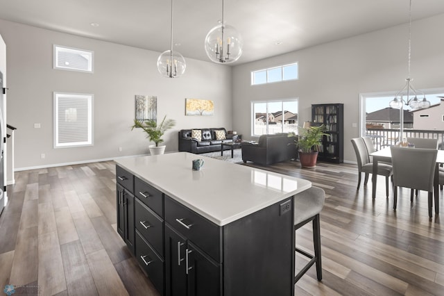 752 Cathy Dr W, West Fargo, ND 58078 - kitchen with wood finished floors, dark cabinets, an inviting chandelier, light countertops, and open floor plan